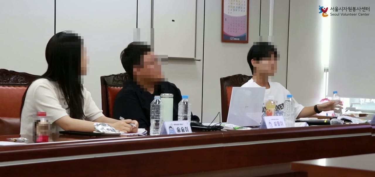 회의실에 앉아 대화를 듣는 참가자들